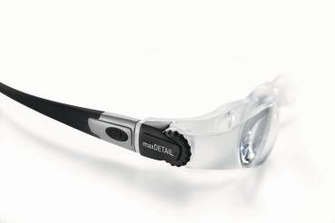 The image shows a pair of glasses with transparent lenses. On one temple, there is a black control panel with a button and a dial for adjustment.