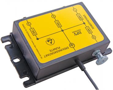 The image shows a rectangular, black device with a yellow sticker. On the sticker are diagrams and labels. A cable leads from the side of the device.