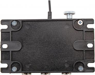 The image shows a flat, rectangular, black device with a slightly textured surface. At the top, there is a cable and a rotary knob. Hexagonal screws are visible at the corners.