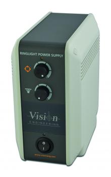 The image shows a rectangular, gray device with a dark front. It features two round dials and a power switch at the bottom. On the front, it reads "Vision Engineering" and "Ringlight Power Supply".