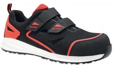 Der Schuh ist schwarz mit roten Akzenten. Er hat zwei breite Klettverschlüsse und eine verstärkte Zehenkappe. Die Sohle ist hell und hat ein grobes Profil für besseren Halt.