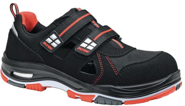 Der Schuh ist schwarz mit roten Akzenten. Er hat zwei Klettverschlüsse, eine sportliche Form und eine gepolsterte Sohle. Material wirkt robust und ist für den Arbeitseinsatz geeignet.