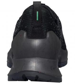 Das Bild zeigt die Rückansicht eines schwarzen Sportschuhs. Die Sohle ist robust und hat ein griffiges Muster. Am Schuh befindet sich ein grüner Streifen oben in der Mitte.
