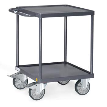 The image shows a dark handcart with two shelves. It has four large, movable wheels and a handle for pushing. The structure is sturdy and practical.