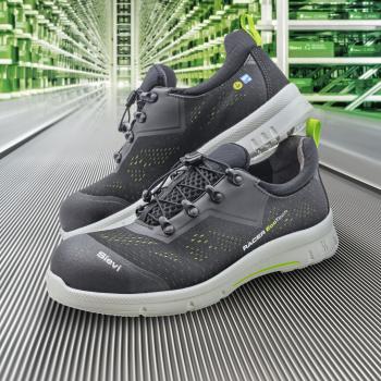 Das Bild zeigt ein Paar schwarze Sport- bzw. Arbeitsschuhe mit gelben und grünen Akzenten. Sie sind ergonomisch geformt und sehen leicht aus, ideal für aktive Nutzung.