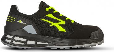 The shoe is black with bright yellow laces and a yellow logo. It has a sturdy sole with gray and black elements, ideal for sports and exercise.