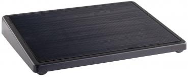 The image shows a rectangular, flat plate with a textured, matte black surface and rounded corners. It stands on four small feet.