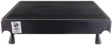 The image shows a black, rectangular platform with a slightly textured surface. It stands on four short legs and has rounded corners. A certificate is attached.