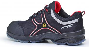 The shoe is a black sneaker with red and silver accents. It has a sturdy sole, laces, and is designed for safety and comfort.