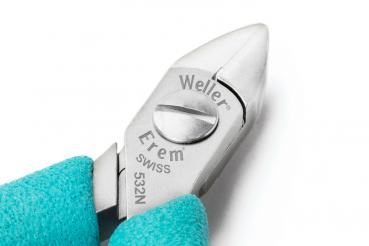 The image shows a small pair of pliers with a sharp, metallic cutting edge and a blue handle. On the metal, it reads "Weller Erem Swiss 532N". The pliers are precise and handy.