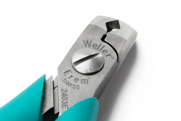 The image shows a pair of pliers with a metal head and grippy, turquoise handles. The head has a cutting edge and a central adjusting screw.