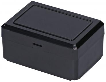 Das Bild zeigt eine rechteckige, schwarze Box mit einem flachen Deckel. Die Ecken sind abgerundet, und die Oberseite hat eine leicht erhabene Fläche. Sie scheint glatt und glänzend zu sein.