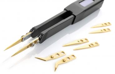 In the image, there is a black electronic tweezer with two pointed gripping arms and several small, golden cutting blades. The blades are of various shapes.