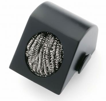 The image shows a black, slanted block with a round opening. Inside, there is a silver metal grid. It could be a cleaning brush.