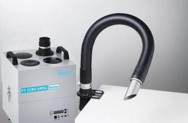 The image shows a smoke extraction device. It has a large, gray body with several openings on top. A flexible hose leads to an open, black exit area.