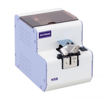 The image displays a white device from OHTAKE. It features a square shape, a transparent cover on top, and a connection for practical use on the front.
