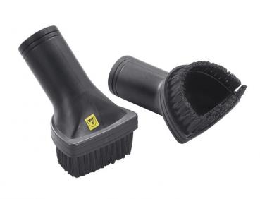 The image shows two black brush attachments. Both have a sturdy handle. One has soft bristles, the other is wide and has a rounded shape with rubber edges.