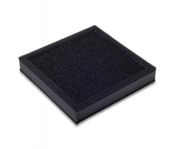 The image shows a square, flat object in black with a rough, textured surface. It has a matte finish and looks like a cushion or pad.