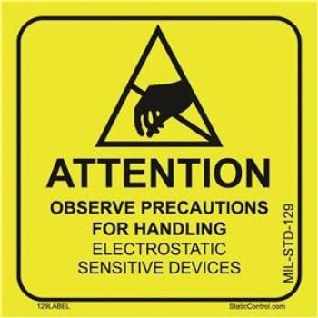 The image shows a yellow warning sign with a black triangle and a hand holding an electrical device. Below it reads: 
