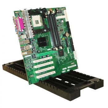 The image shows a green circuit board, designed with many small components, wires, and slots. It is tilted on a black, sturdy surface.