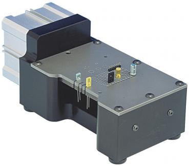 The image shows a technical device with a rectangular casing. At the top, there is a flat metal plate with several small components. On one side, a silver heat sink protrudes.