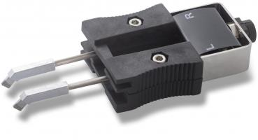 The image shows a technical device with a black handle section and two long, metallic tongs. On the top, there is a switch labeled with the letters 