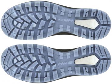 The image displays the soles of a pair of sports shoes. They feature a textured tread with rubber sections and a bright, shiny element in the center. The soles are symmetrically arranged.