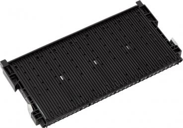 The image shows a black, rectangular component with several narrow grooves and slots. It has small protrusions on the sides and appears to be a storage or connecting element for technical devices.