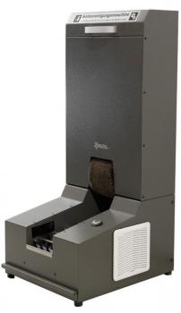 The image shows an automatic shoe cleaning machine made of dark metal. At the top, there is a narrow slot, and below it is a wider area with a brush. On the side, there is a control button and a vent.