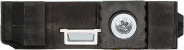 The image shows a black, rectangular plastic component. On one side, there is a round metal piece with a screw. Next to it is a small, rectangular cutout.