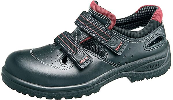 The shoe is black with green accents and features a reinforced toe guard. It has two adjustable Velcro straps and a grippy, textured sole. Ideal for work or leisure.