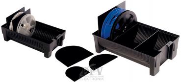 The image shows a black container with four round, white plates. One of the plates is tilted and two black dividers stand in the box. The structure is functional and simple.