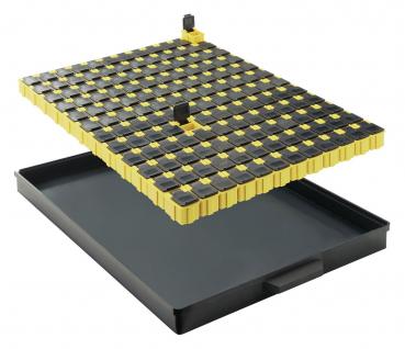 Das Bild zeigt eine abnehmbare Platte mit vielen kleinen, schwarzen und gelben Tasten auf einer schwarzen, flachen Schale. Die Tasten sind in einem regelmäßigen Muster angeordnet.