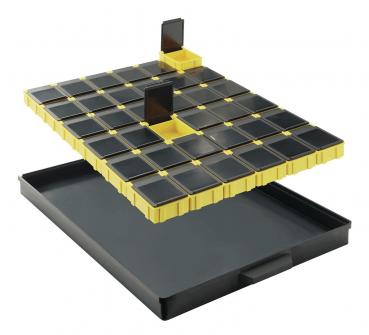 Das Bild zeigt eine schwarze Aufbewahrungsbox mit einem abnehmbaren gelben Deckel. Der Deckel hat viele kleine Fächer und zwei hohe Trennwände in der Mitte. Die Box dient zur organisierten Lagerung.