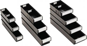 The image shows a narrow, rectangular container made of black plastic. It has a clear front where a label can be attached. The container features several internal dividers.