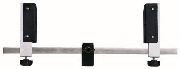 The image displays a metal device with a long central rod. At both ends, there are black, padded holders. In the center, there is a small black screw.