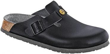 Der Schuh ist ein schwarzer Clog ohne Ferse. Er hat eine breite, abgerundete Spitze und einen Riemen mit einer Schnalle auf der Außenseite. Die Sohle ist rutschfest und leicht erhöht.