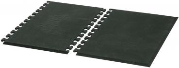 The image displays a black, rectangular mat with bumps in a circular area on one side. The mat features connectors at the edges to attach it to other mats.