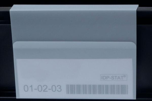 The image shows a white envelope with a transparent flap. On it are numbers ("01-02-03") and a barcode printed. The background is dark.