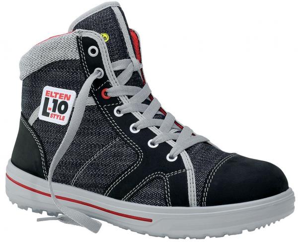 Der Schuh ist ein hoher, sportlicher Sicherheitsstiefel aus schwarzem Material mit grauem Textil. Er hat weiße Schnürsenkel, eine robuste Gummisohle und eine rot-weiße Markenaufkleber.