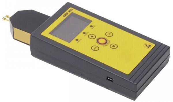 The image shows a portable measuring device with a black casing and yellow buttons. It has a digital display and a detachable sensor at the top. Ideal for technical measurements.