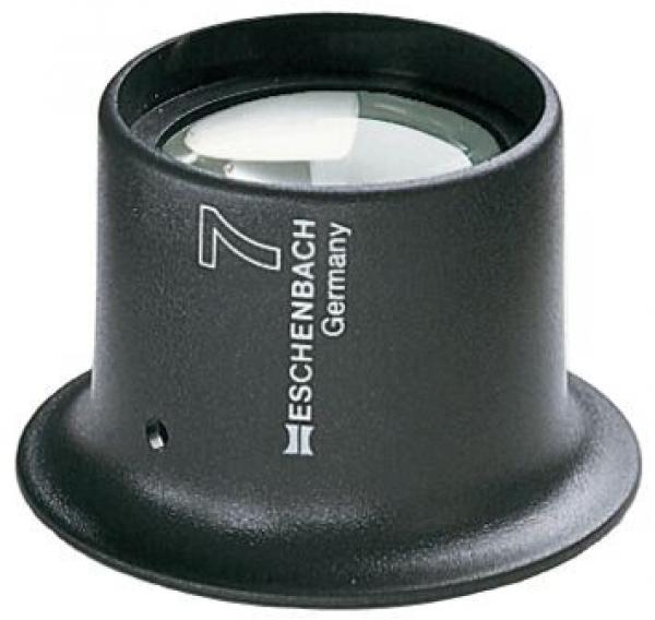 The image shows a black magnifying glass with highly curved glass. The base is round and has a matte finish. On the side, it reads "Eschenbach Germany" and the number "7".