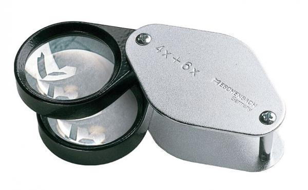 In the picture, there is a double magnifying glass that has two lenses: one for 4x and one for 6x magnification. The frame is black and silver. The lenses are clear and round.