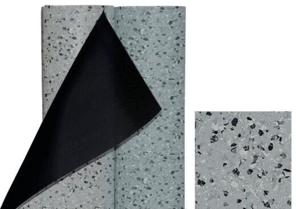 Das Bild zeigt ein graues Bodenbelagsmaterial mit kleinen, dunklen und hellen Partikeln. Ein Teil des Materials ist aufgerollt und zeigt die darunterliegende schwarze Schicht. Daneben befindet sich ein kleines Stück des gleichen Materials.