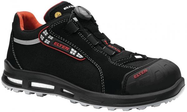 Der Schuh ist schwarz mit roten und weißen Akzenten. Er hat einen robusten, rutschfesten Sohlenbereich und eine gepolsterte Innensohle. Am oberen Teil befindet sich eine Schnellschnürung.