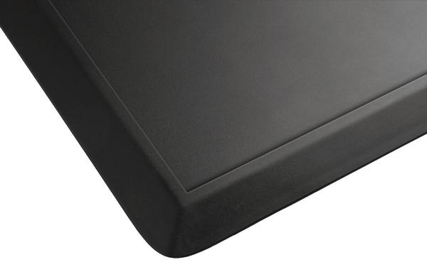 The image displays a black, matte surface with slightly rounded edges. At one corner, there is a fine line that subtly interrupts the texture of the surface.