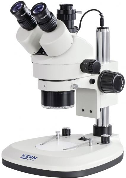 The image shows a microscope in white and silver. It has two eyepieces on top, a long body, and various adjustment options on the side. The base is stable and flat.