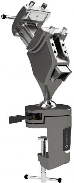 The image shows a gray device with two arms that are connected by a type of joint. There is a solid handle at the bottom and a clamp for attachment.