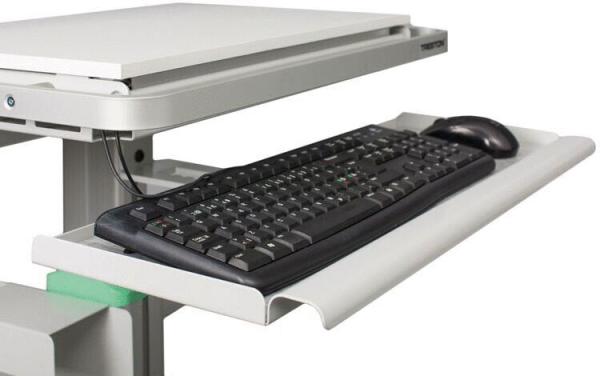 Das Bild zeigt einen Schreibtisch mit einer ausziehbaren Tastaturablage. Auf der Ablage liegt eine schwarze, flache Tastatur und daneben eine schwarze Computermaus. Die Oberfläche ist hellgrau.