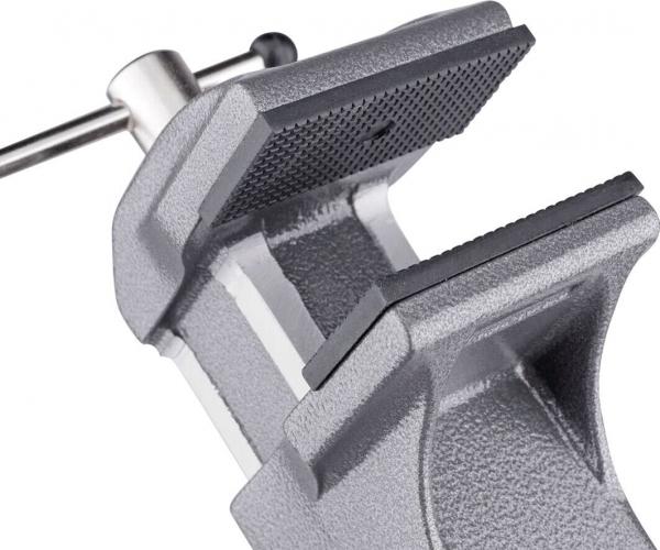The image shows a gray metal vise. It has two wide, flat jaws that serve to hold objects. A screw on the side allows the opening and closing of the jaws.